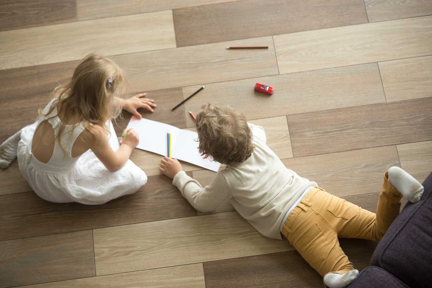 A picture of two children playing on the vinyl flooring - Footprints Floors in  Fort Collins.