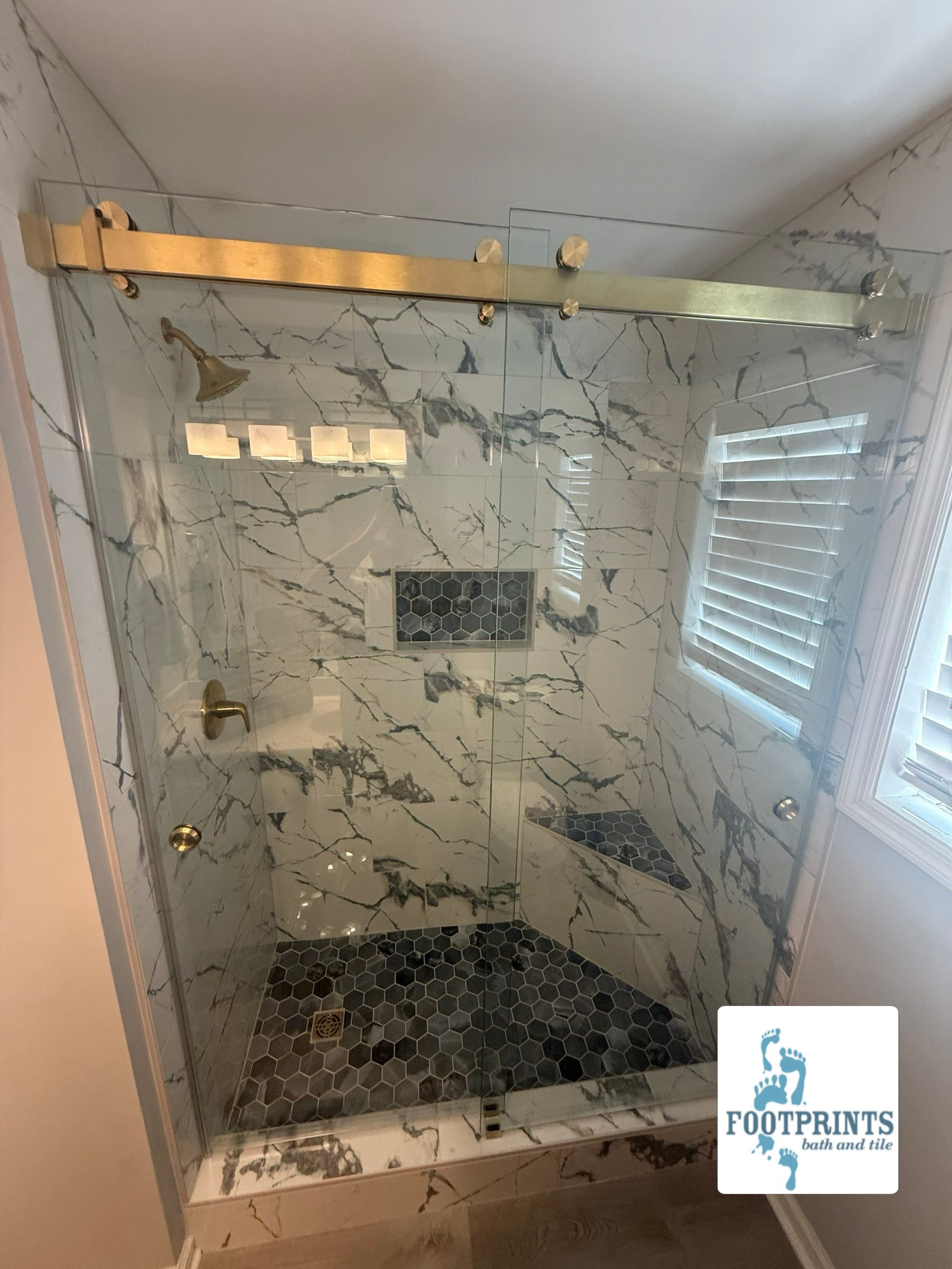 We recently converted a tub/shower combo into this gorgeous walk-in shower, complete with a mosaic-tiled bench seat and shower niche. Swipe for the 5-star review from our happy customer! 