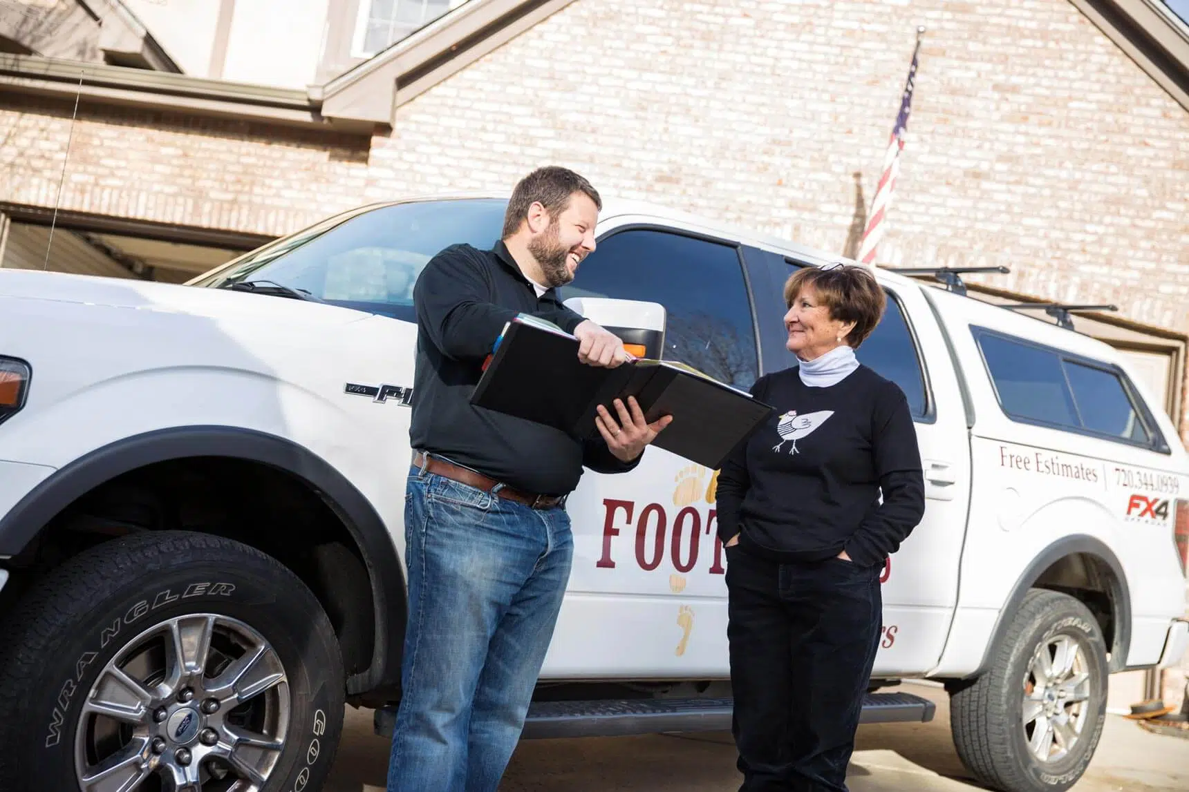 Bryan Park, the founder and CEO of Footprints Floors, talking to another person next to a service vehicle.