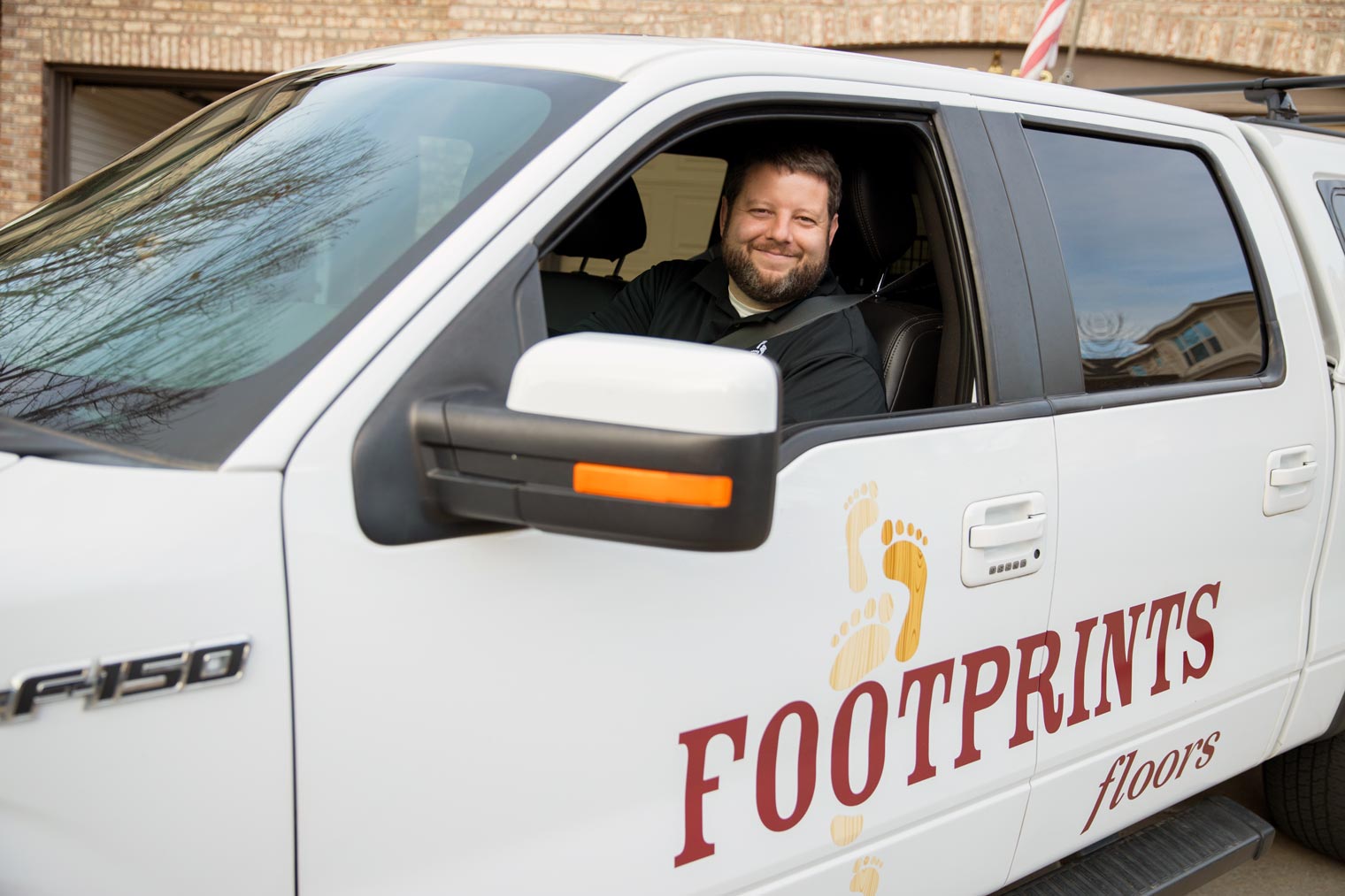 Bryan Park sitting inside a Footprints Floors service vehicle.