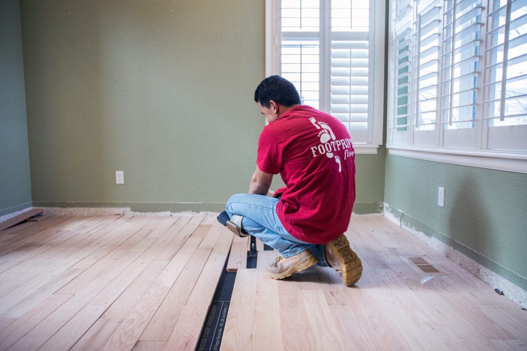 A a Footprints Floors team member installing new flooring in a residential home.