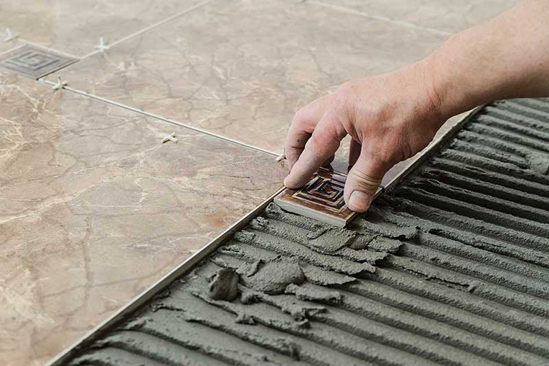 A contractor installing new tiles.