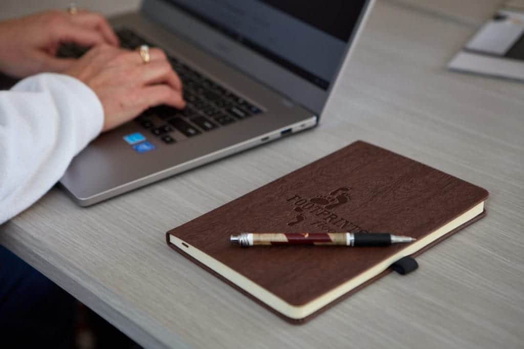 A Footprints Floors notebook sitting on top of a desk - contact us t learn about starting a flooring installation business.