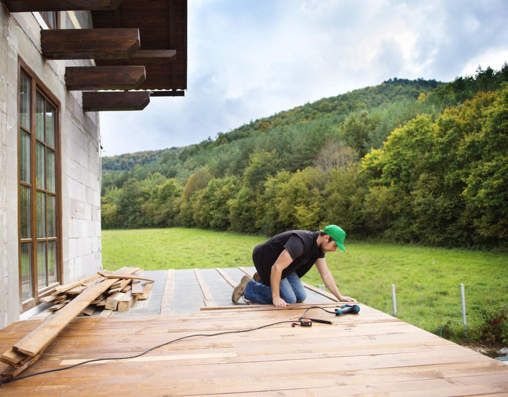 A Footprints Floors team member installing a new flooring on a deck.