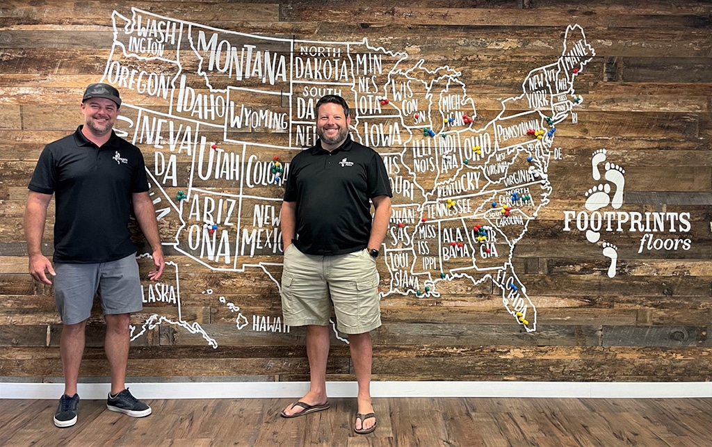 Founder of Footprints Floors Bryan Park and other team member in front of a map for our franchise growth.