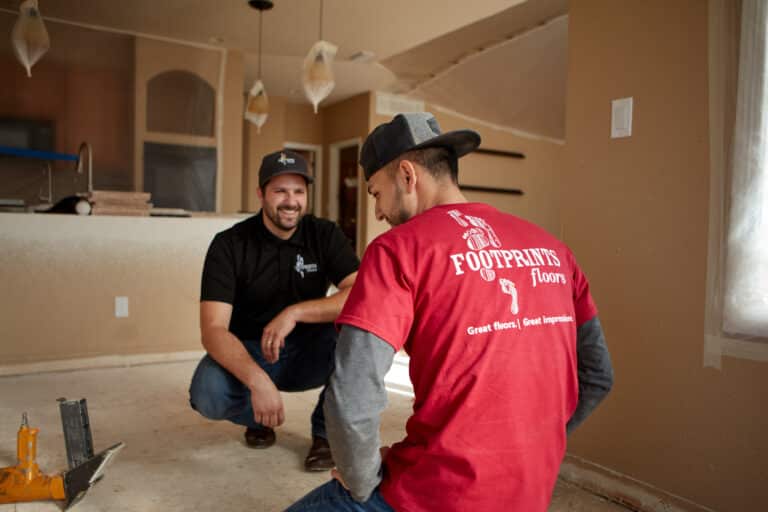 An image of a Footprints Floors owner and a team member working on a flooring project.