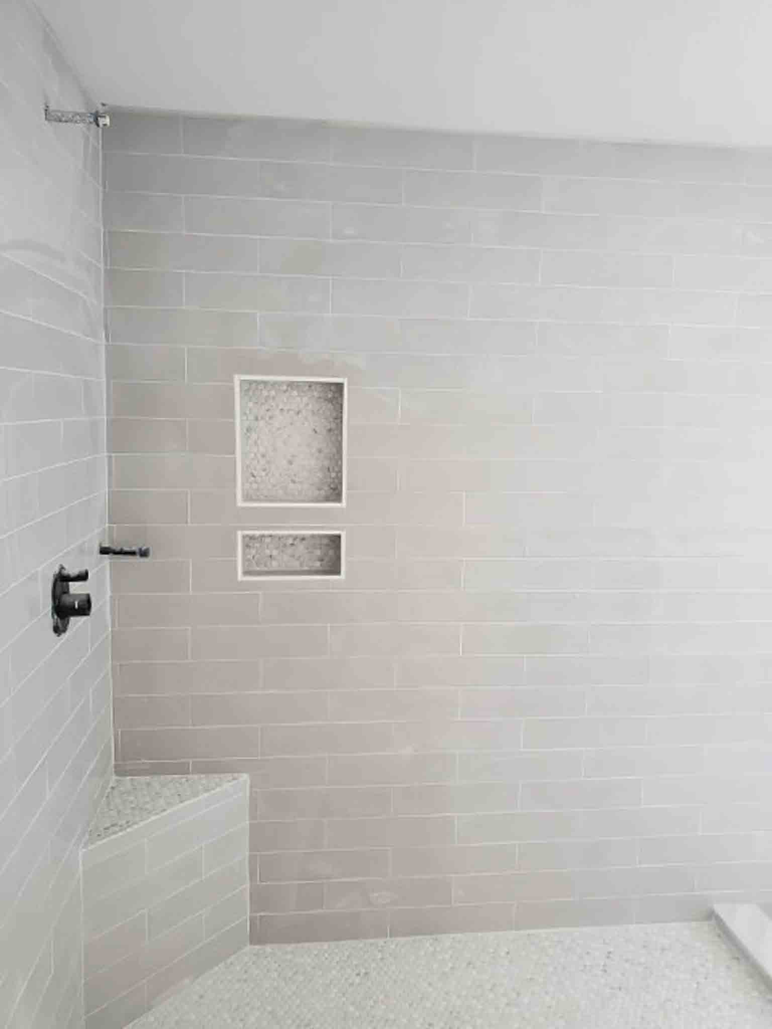A shower with white tiling, installed by Footprints Floors South Sacramento.