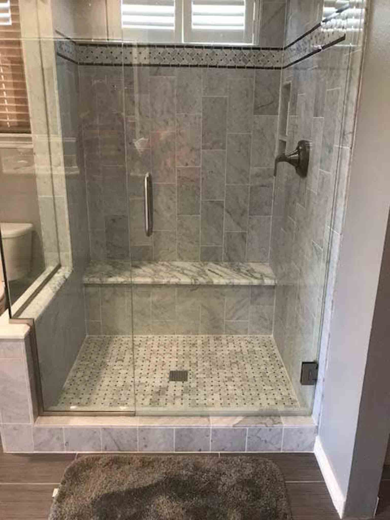 A white and grey tiled shower. 