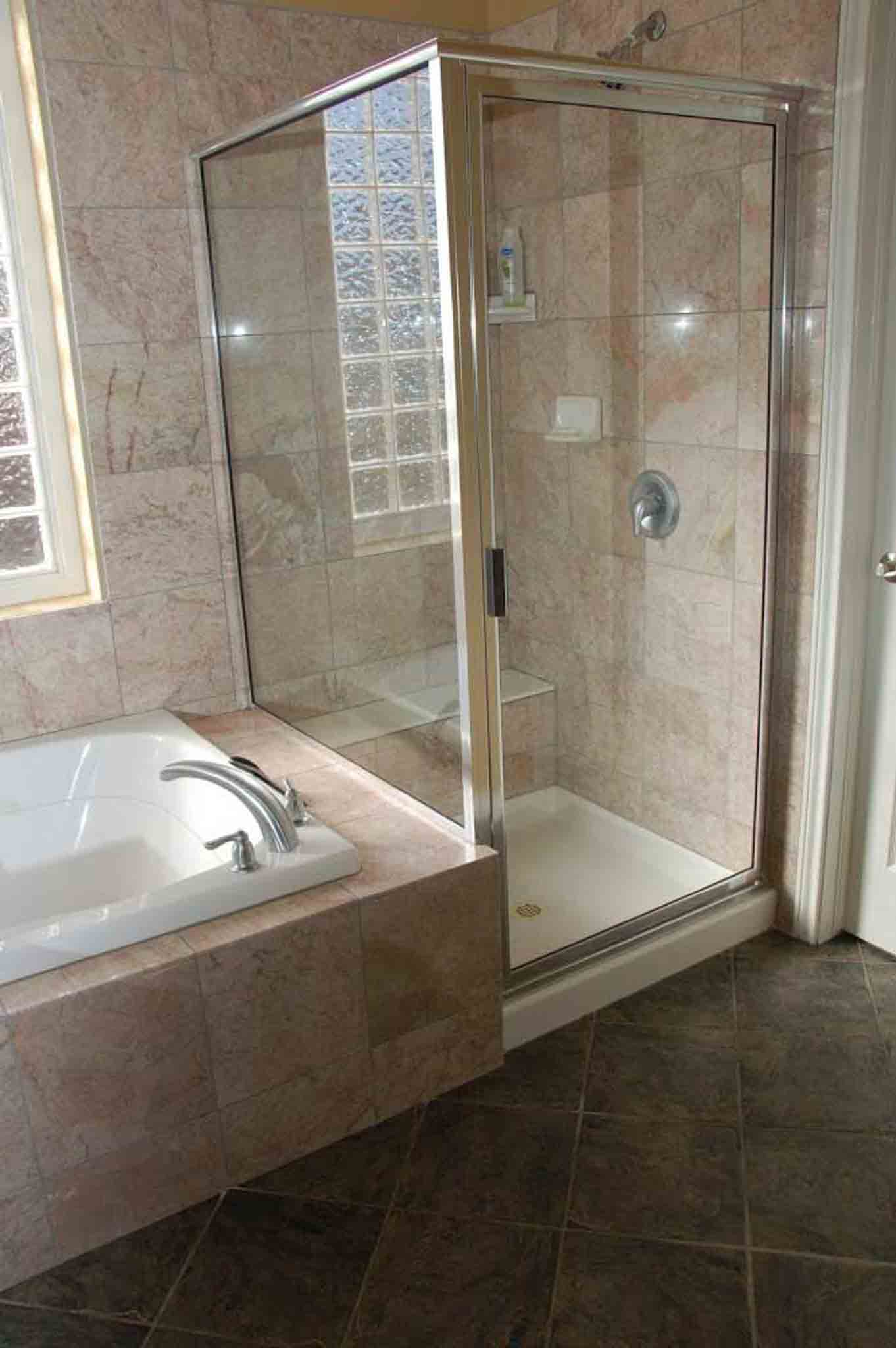 A brown tiled stand up shower.