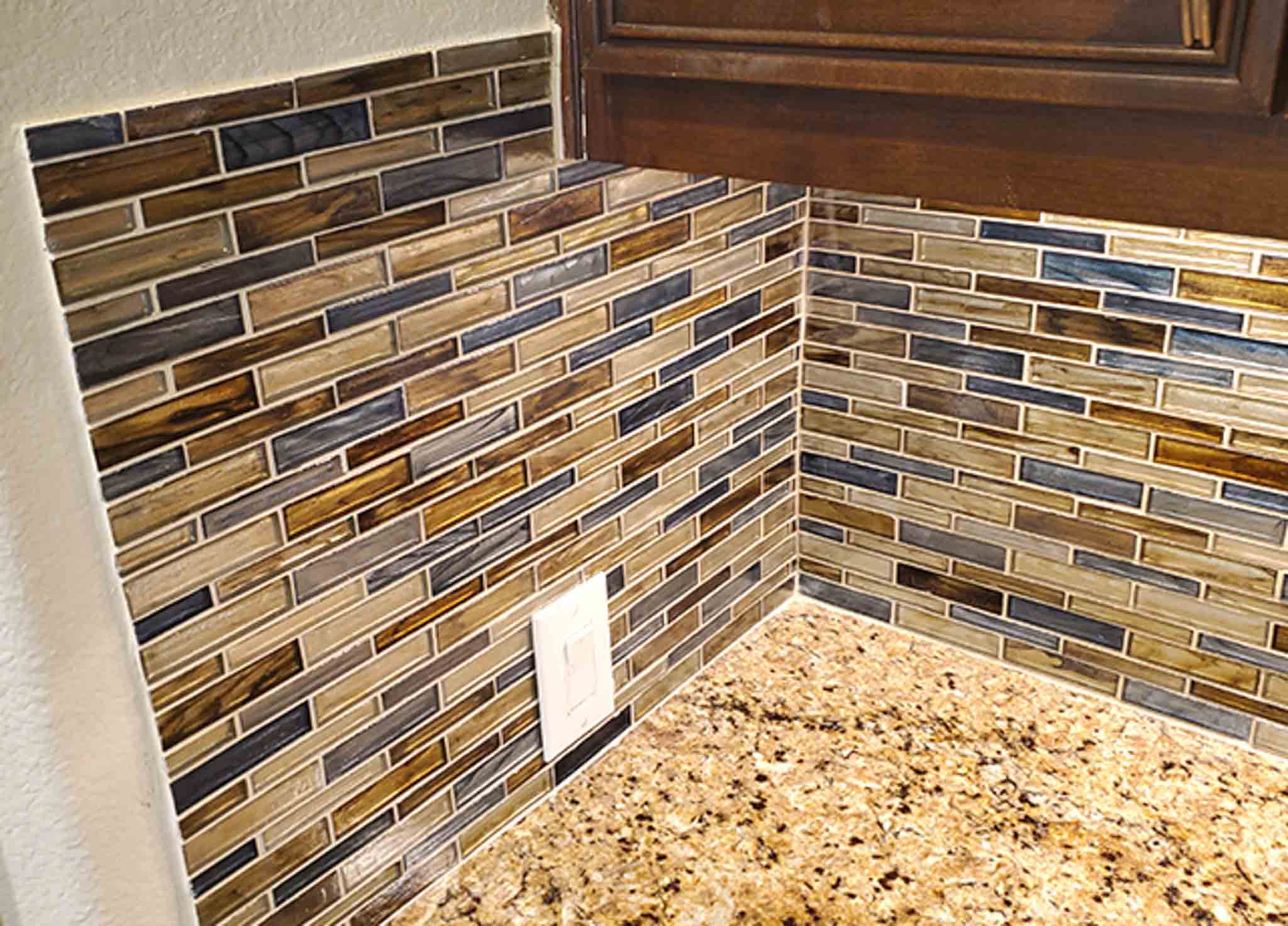 A brown tile backsplash installed in a kitchen.