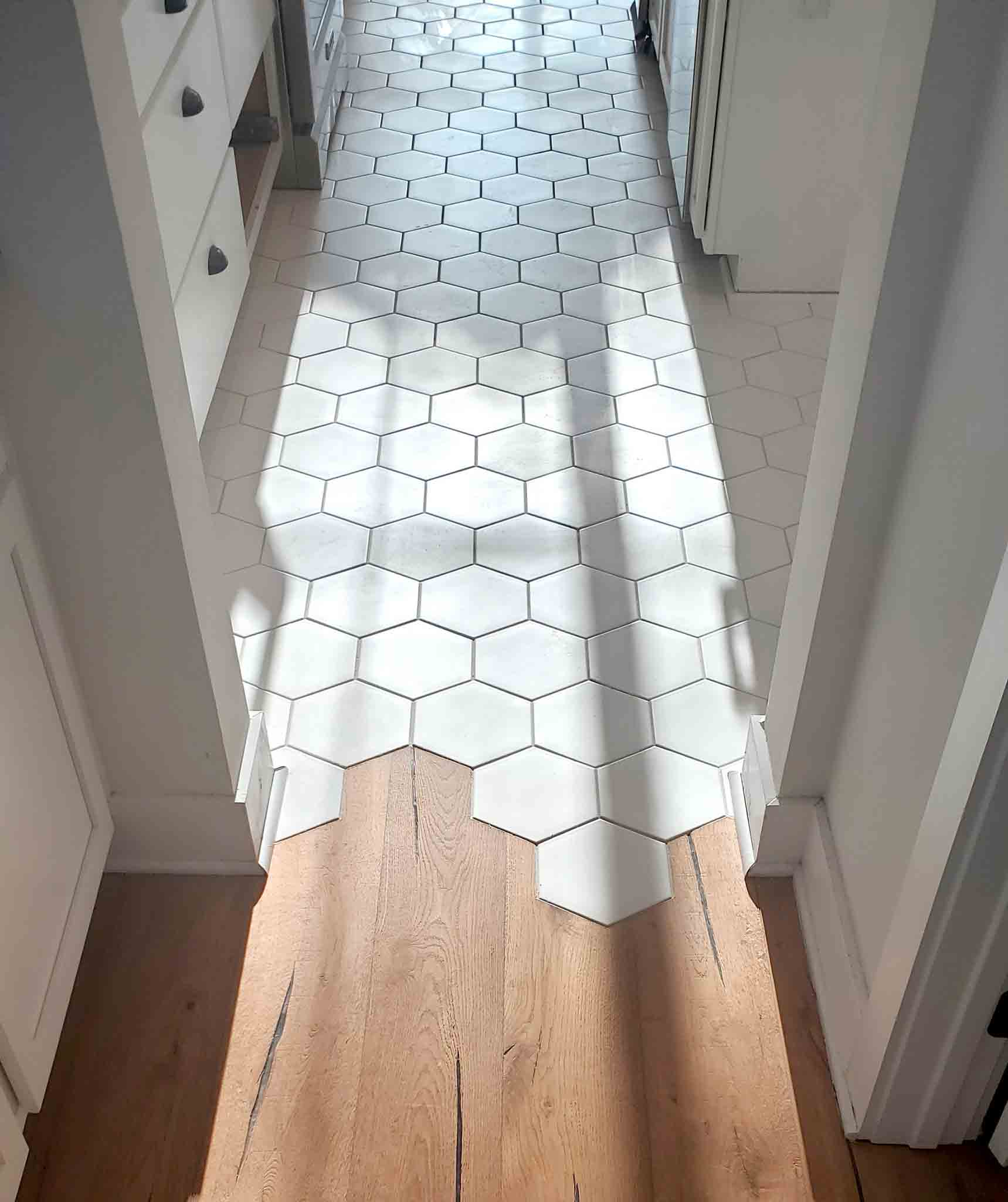 White hexagon tiles and wood flooring, installed by Footprints Floors South Sacramento.