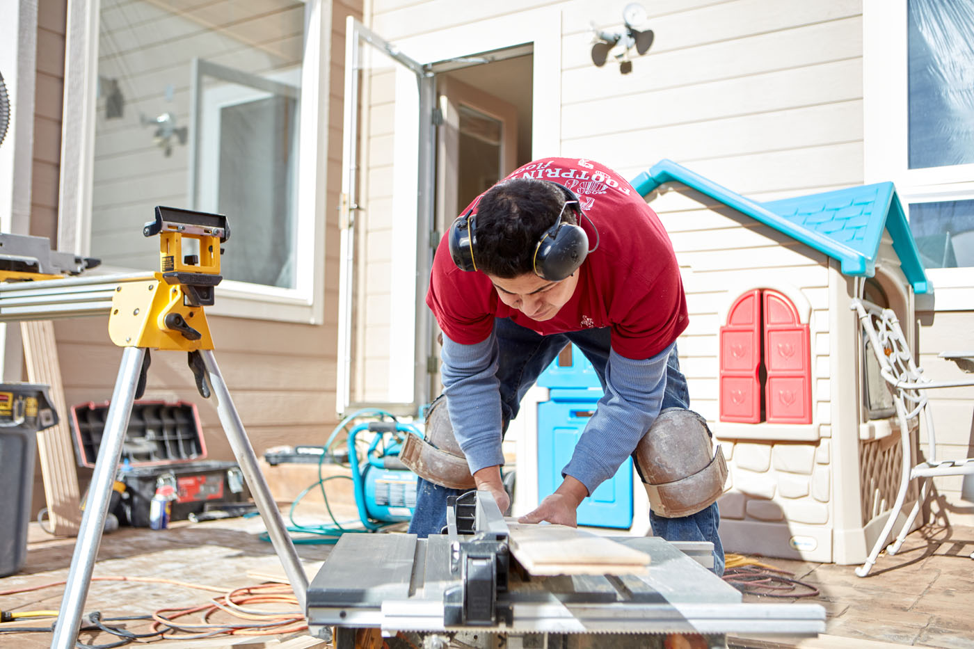 A Footprints Floors worker cutting wood for a flooring project - find success in our changing economy with a handyman franchise.