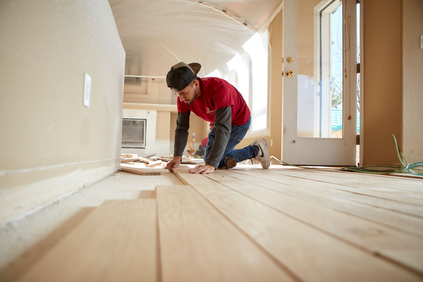 A Footprints Floors technician installing new hardwood floors in a home.
