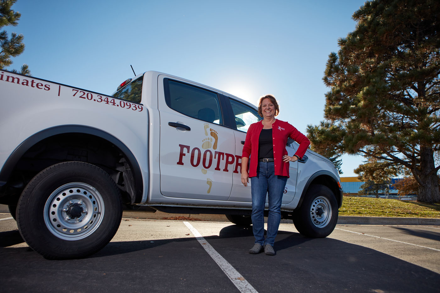 A Footprints Floors team member in front of a branded service vehicle.