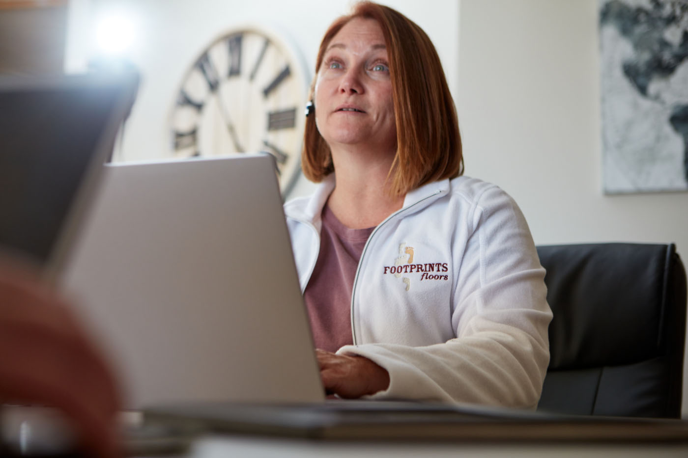 A Footprints Floors Franchise Owner sitting at a computer.