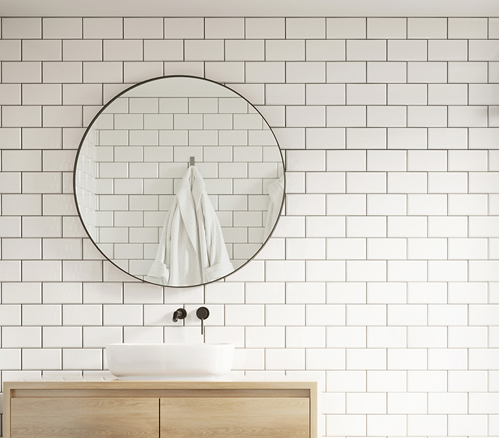 White tile on the wall of a newly renovated bathroom.