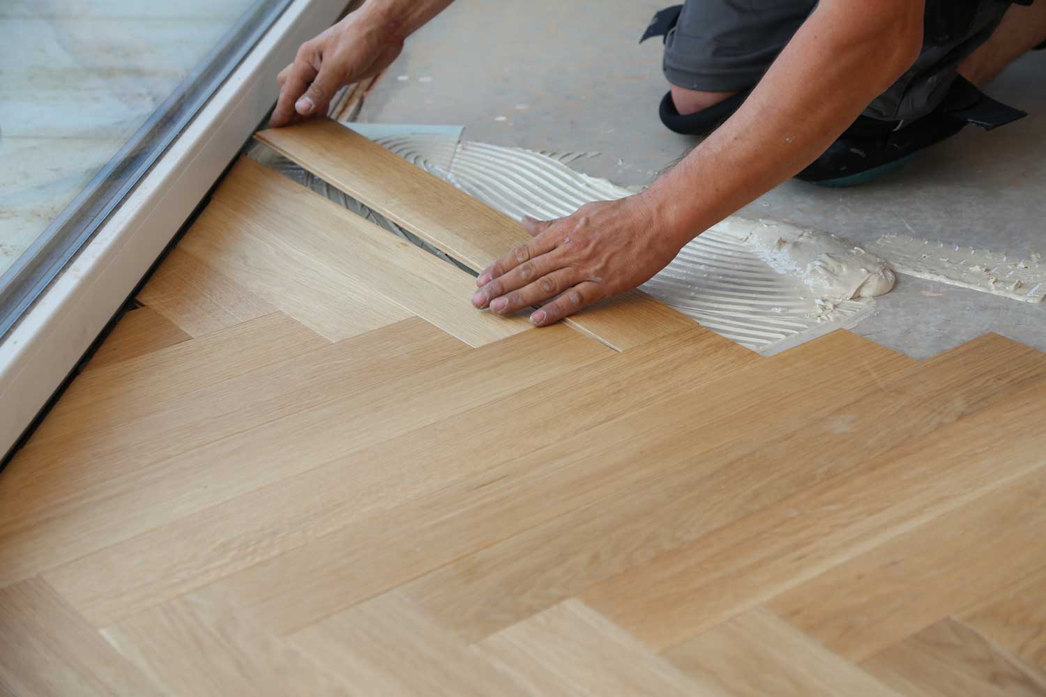 Footprints Floors in Sacramento, CA employee installing hardwood flooring. 