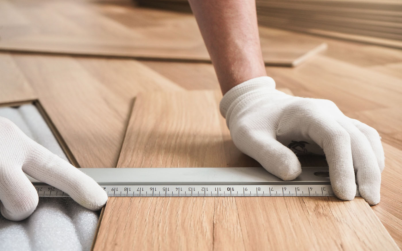A contractor measuring flooring before installing it.