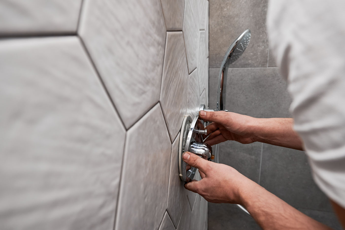 A Footprints Floors contractor finishing a tile installation in a shower.