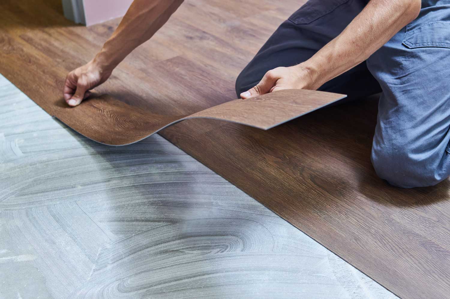 A Footprints Floors professional installs laminate flooring in a home.