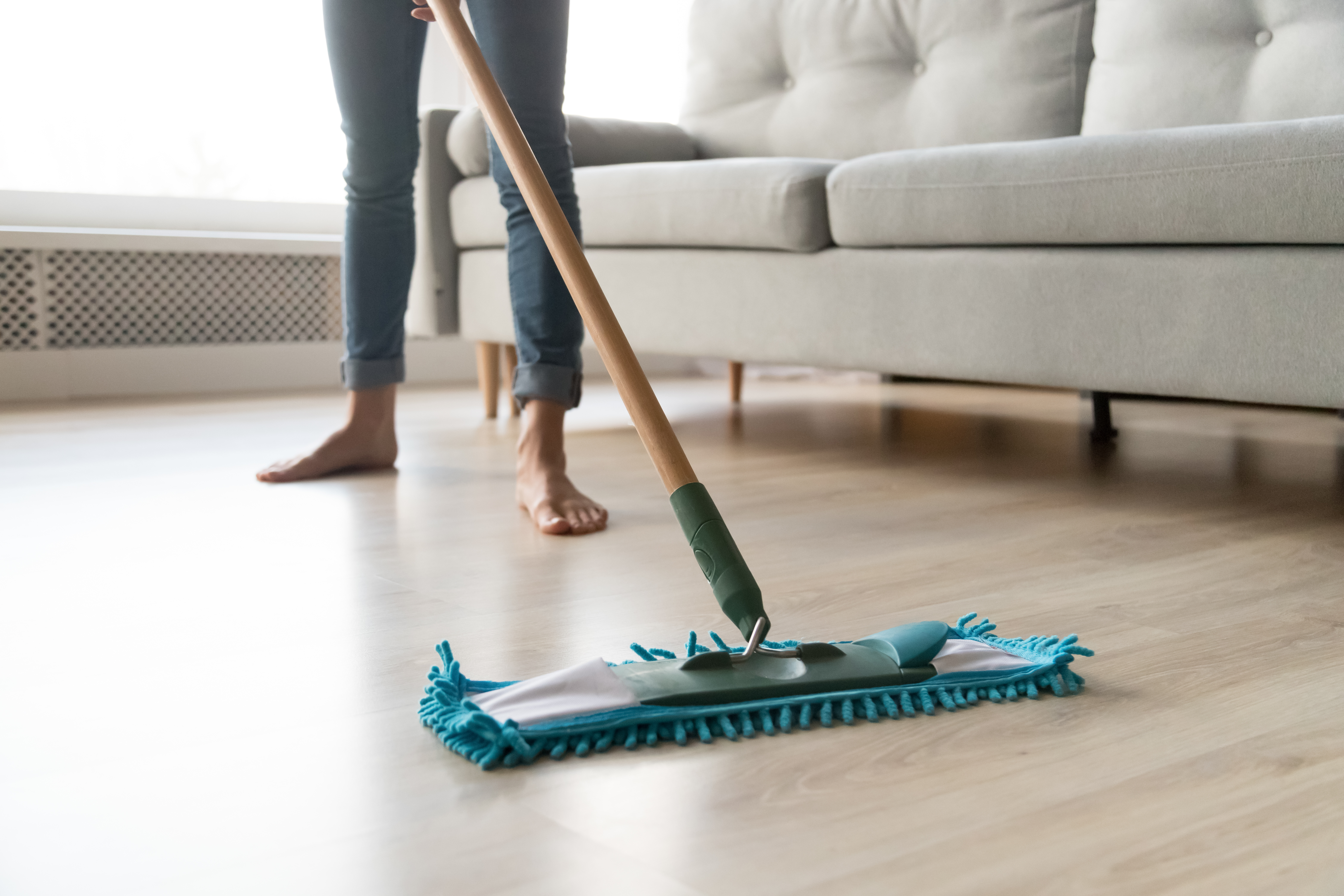 A person cleaning their recently refinished hardwood.