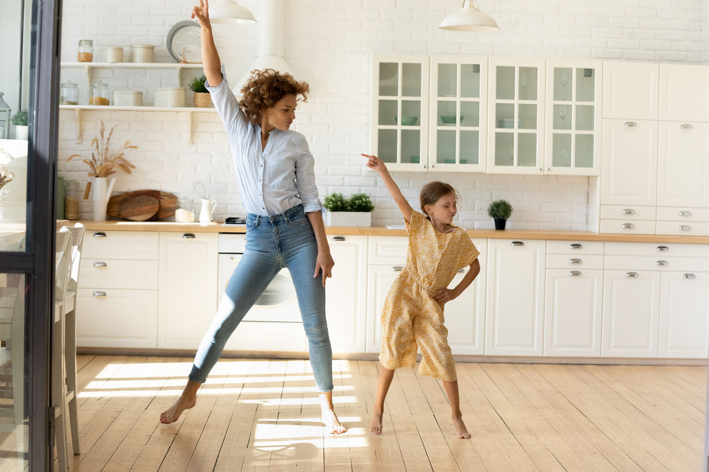 An image showcasing a mother and daughter with hardwood floors refinishing with Footprints Floors.
