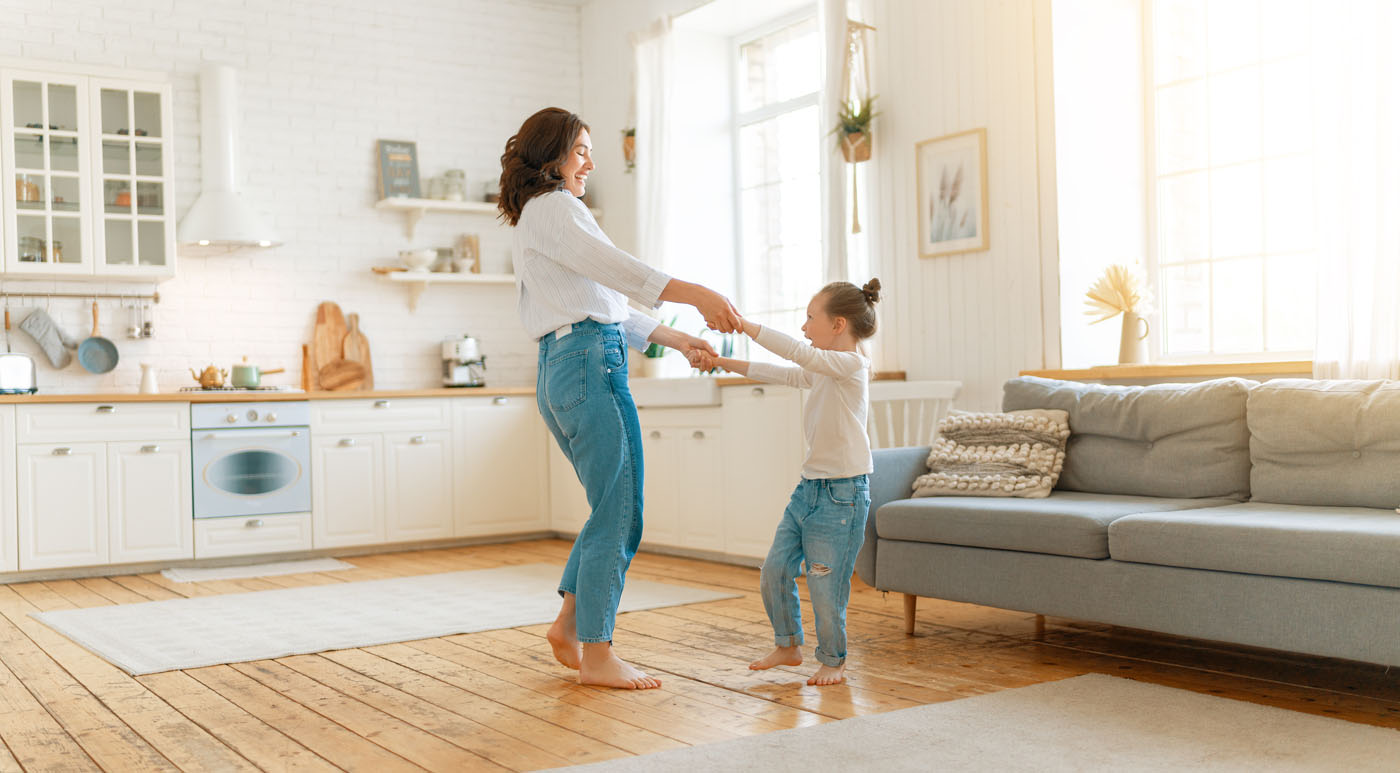 A mother and a daughter dancing on Footprints Floors installed hardwood.