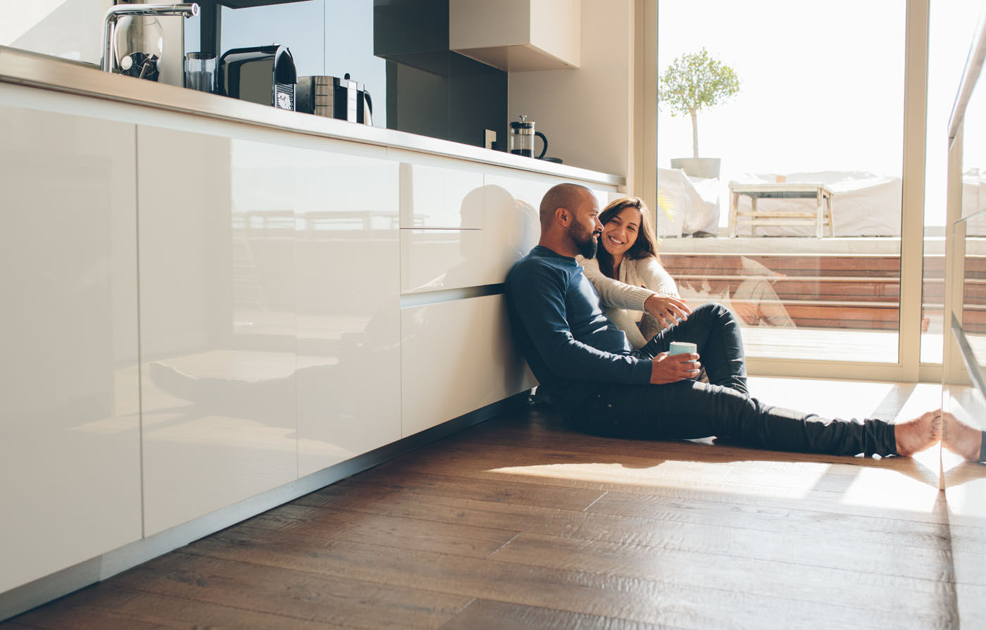 A man and a woman sitting on Footprints Floors flooring - contact us today for vinyl flooring installers in Woodstock, GA.