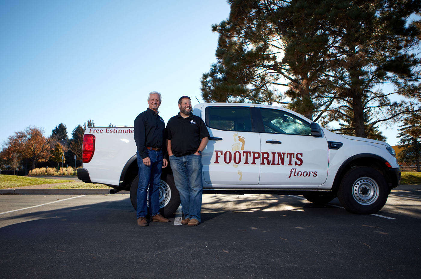 A picture of Footprints Floors technicians, including founder Bryan Park, standing in front of a company truck.