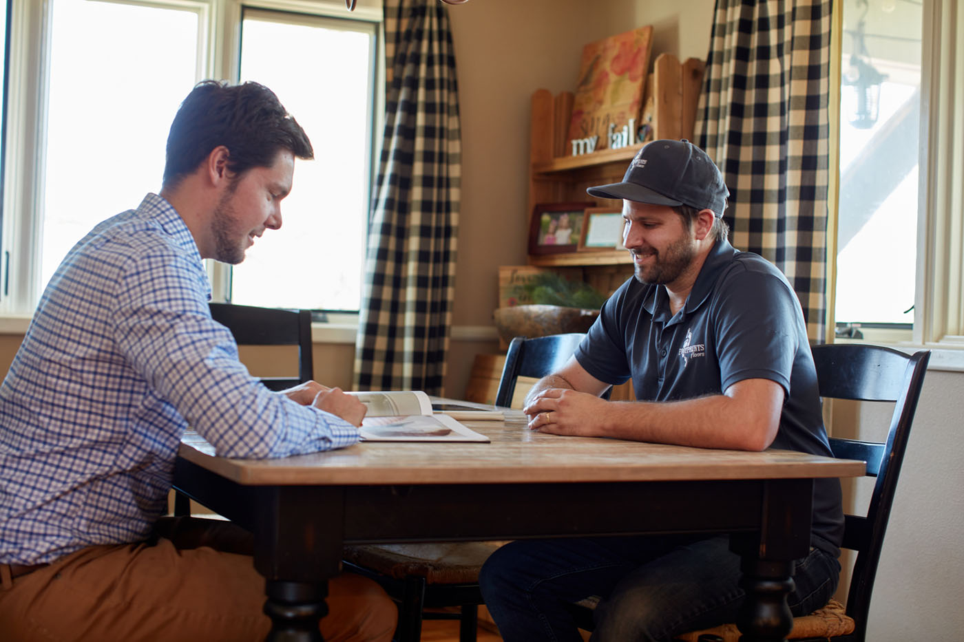 A homeowner sitting down with a Footprints Floors South San José employee, see why customers choose us for flooring and tile installation services in San José, CA.