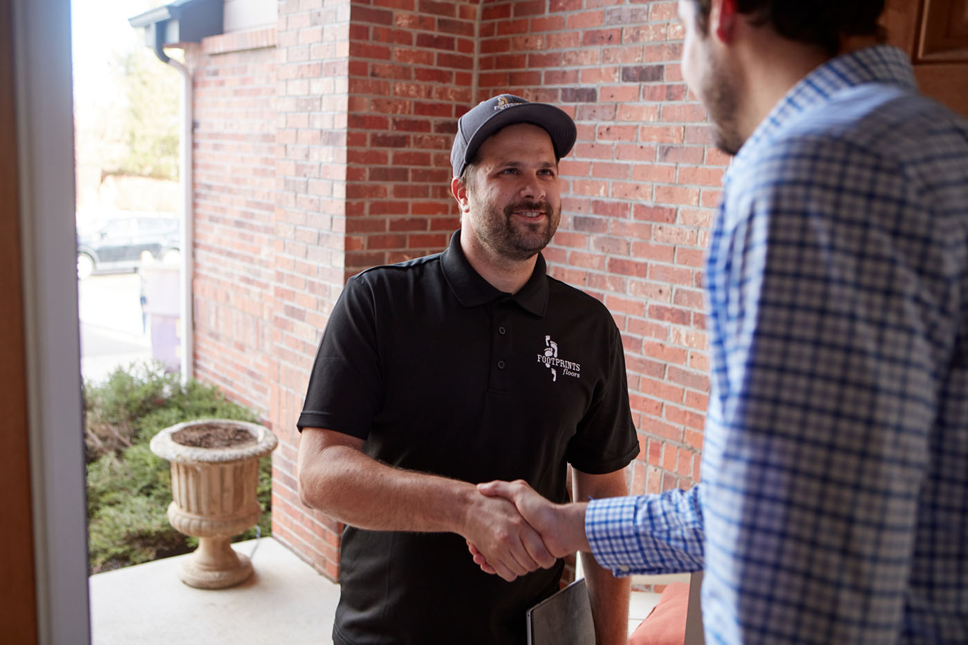 A Footprints Floors team member shaking hands with a customer for a professional led cure refinishing service in Ashburn, VA.