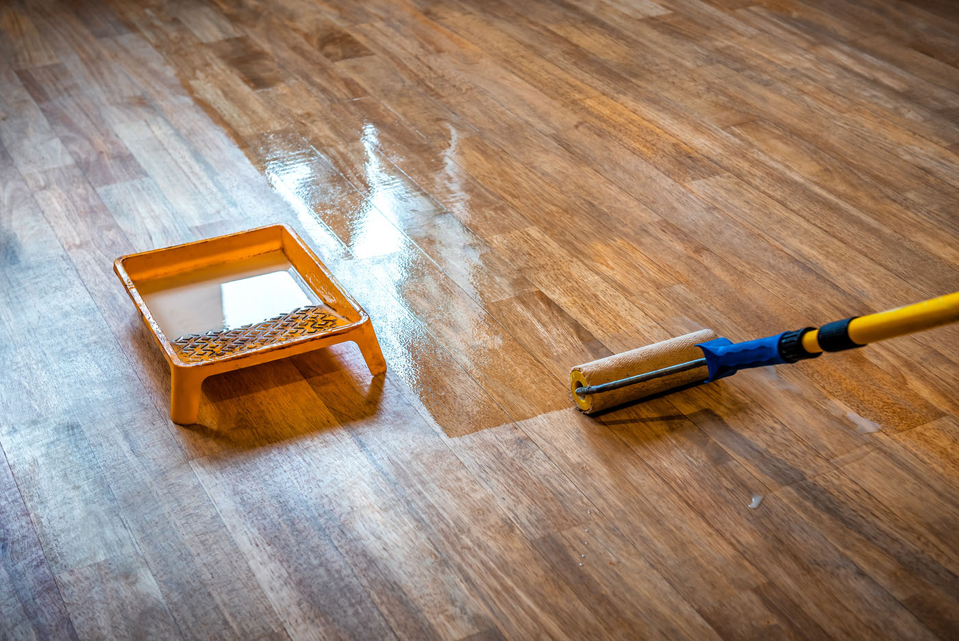 Dark hardwood floor getting a wax coat for led cure refinishing in Ashburn, VA.