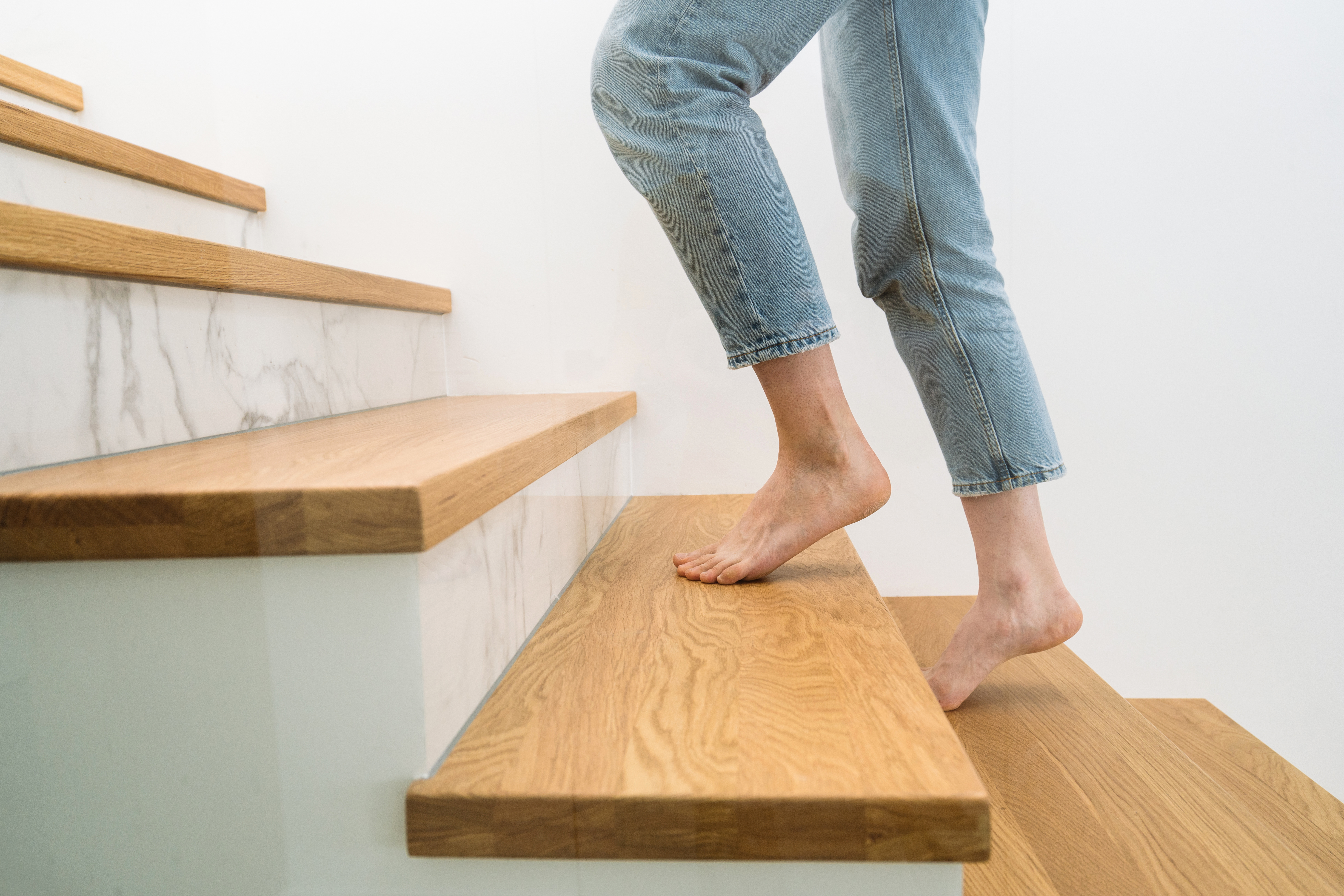 A person walking up newly installed stairs from Footprints Floors.