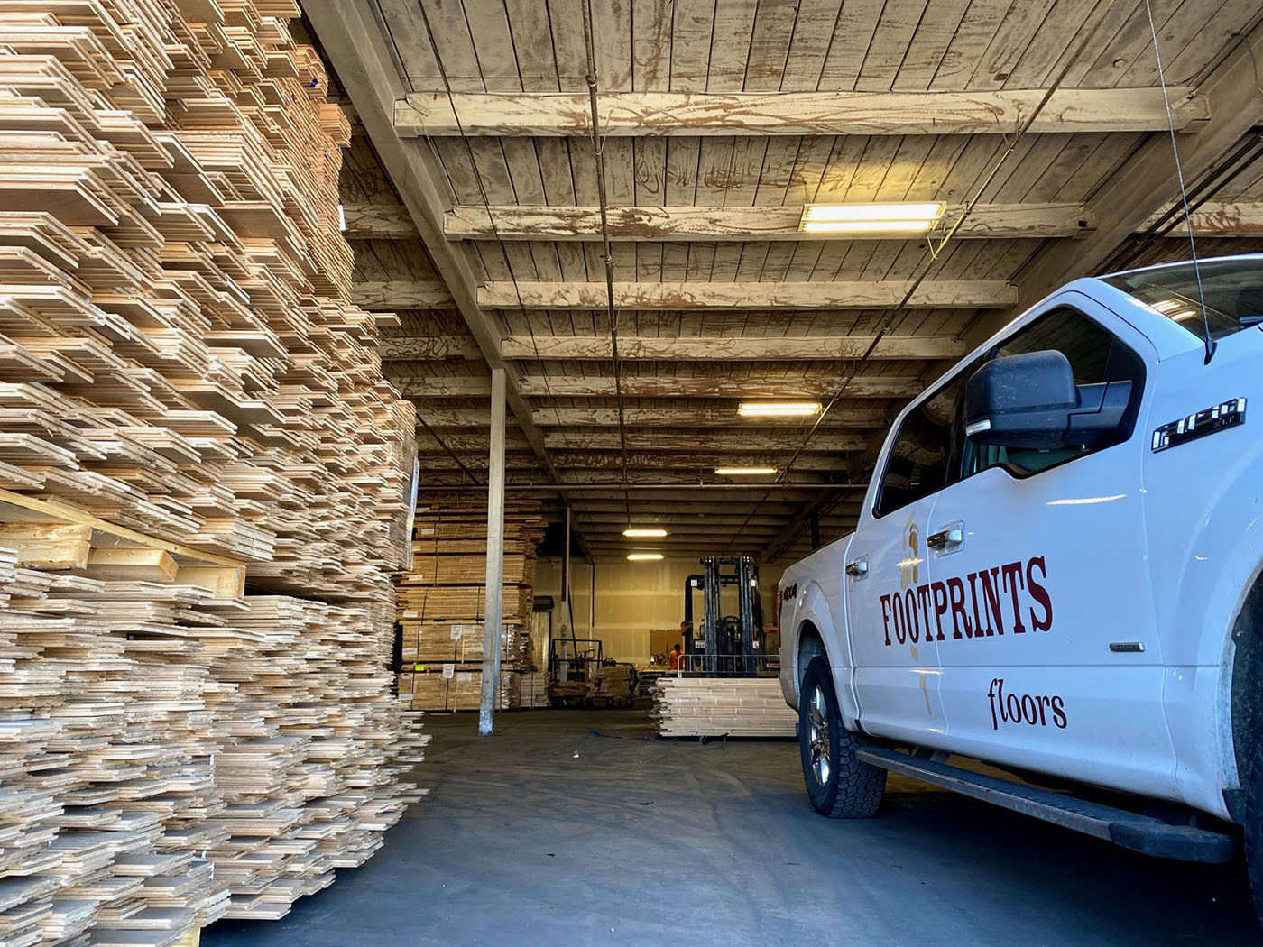 A Footprints pro standing next to one of our service vehicles - trust Footprints Floors, one of the best flooring installation companies in Sacramento, CA to handle your next project.
