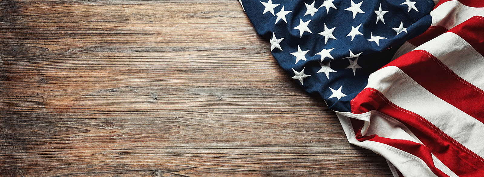 An image of an american flag and hardwood floors - Footprints Floors Little Rock proudly supports our veterans.
